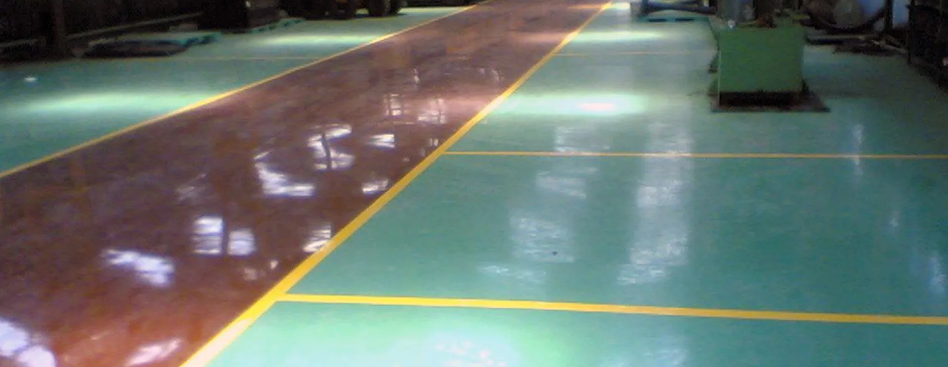 Brown and green factory floor with yellow lines.