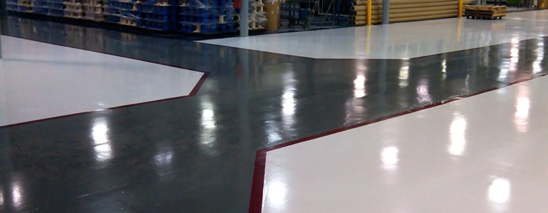 Shiny, multi-colored warehouse floor with white and gray sections, and red borders.