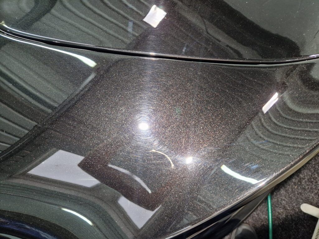 A close up of the hood of a black car.