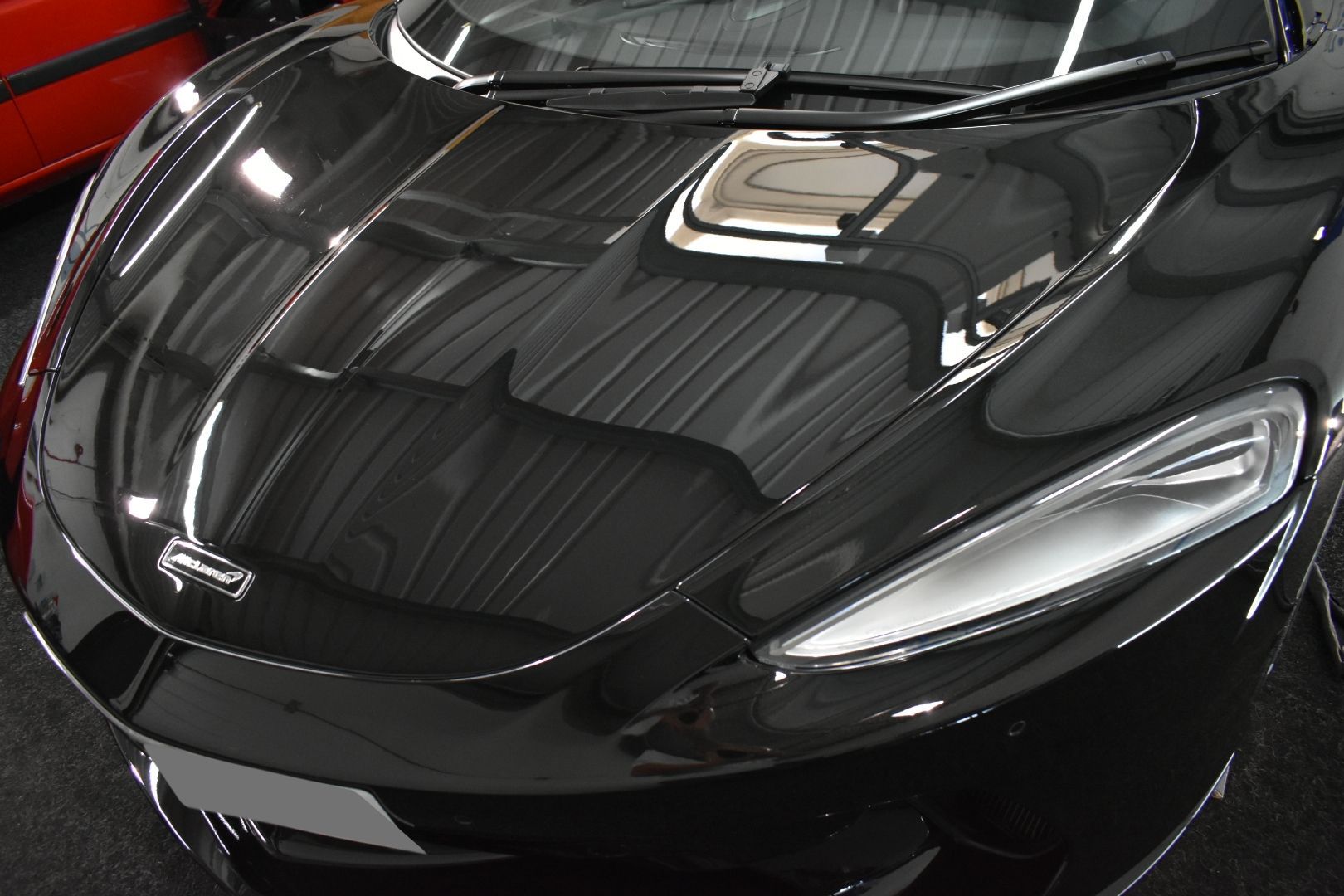 A black sports car is parked in a garage