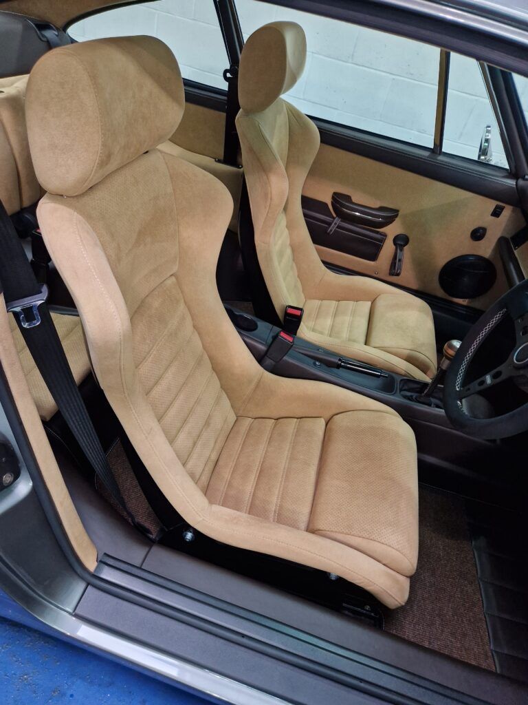 The inside of a car with tan seats and a steering wheel