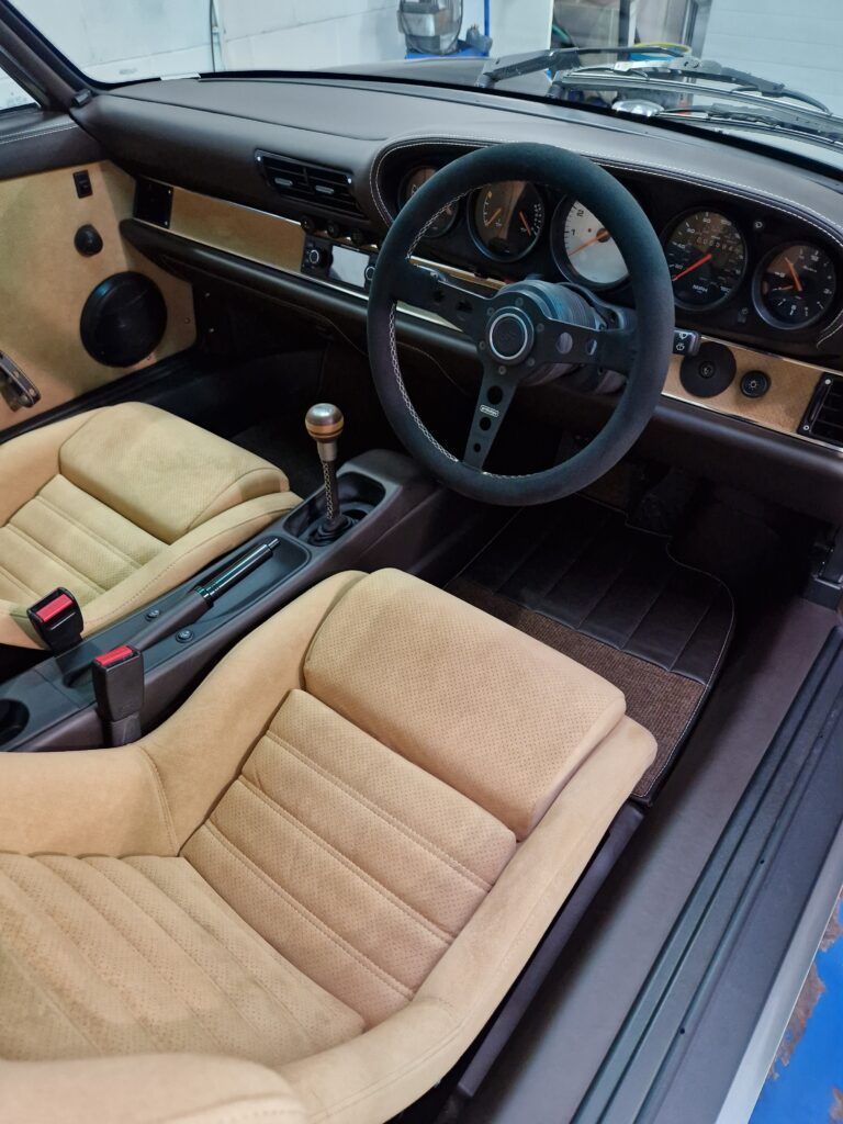 The interior of a car with tan seats and a steering wheel