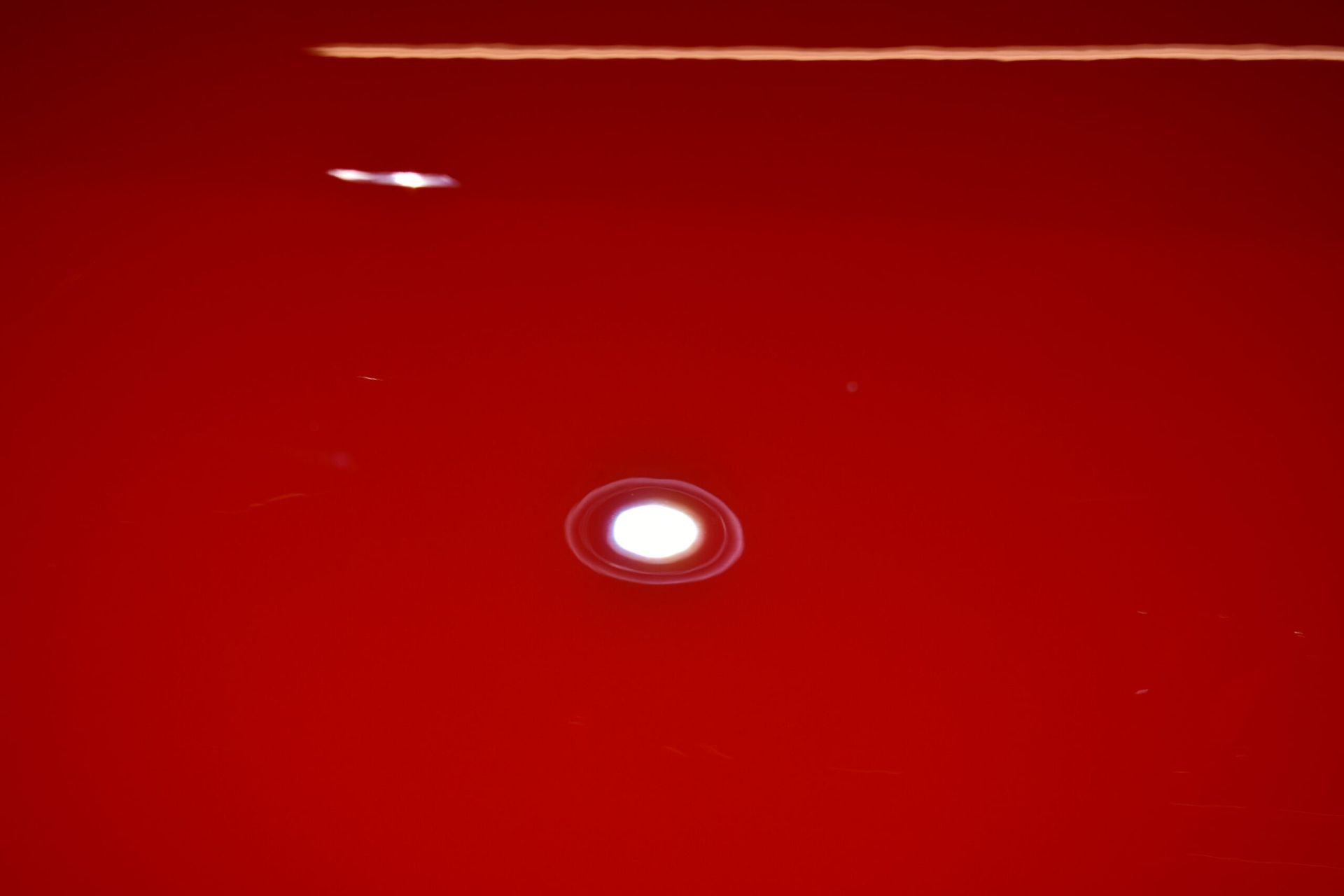 A close up of a red surface with a white circle in the middle.