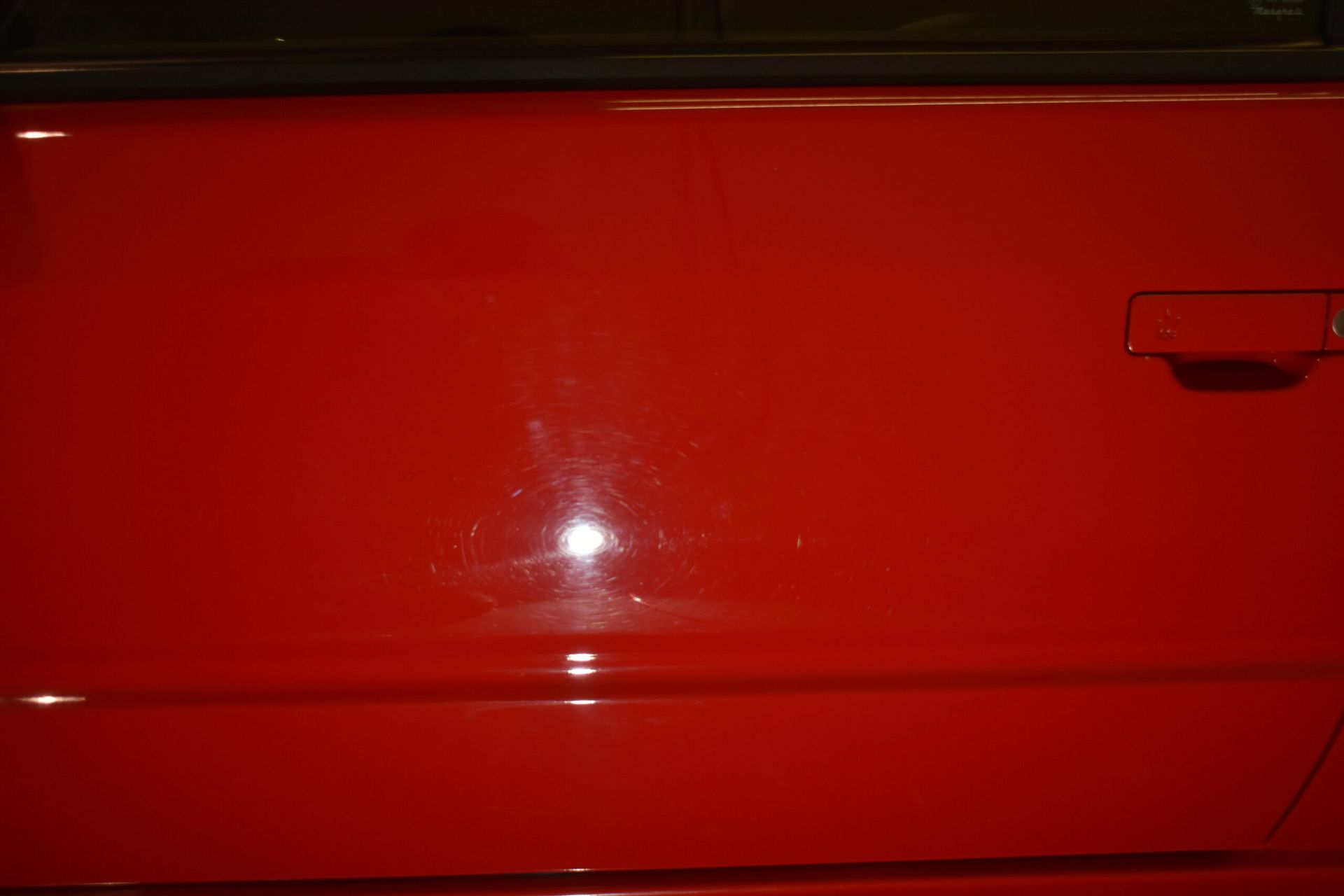 A close up of a red car door with a handle