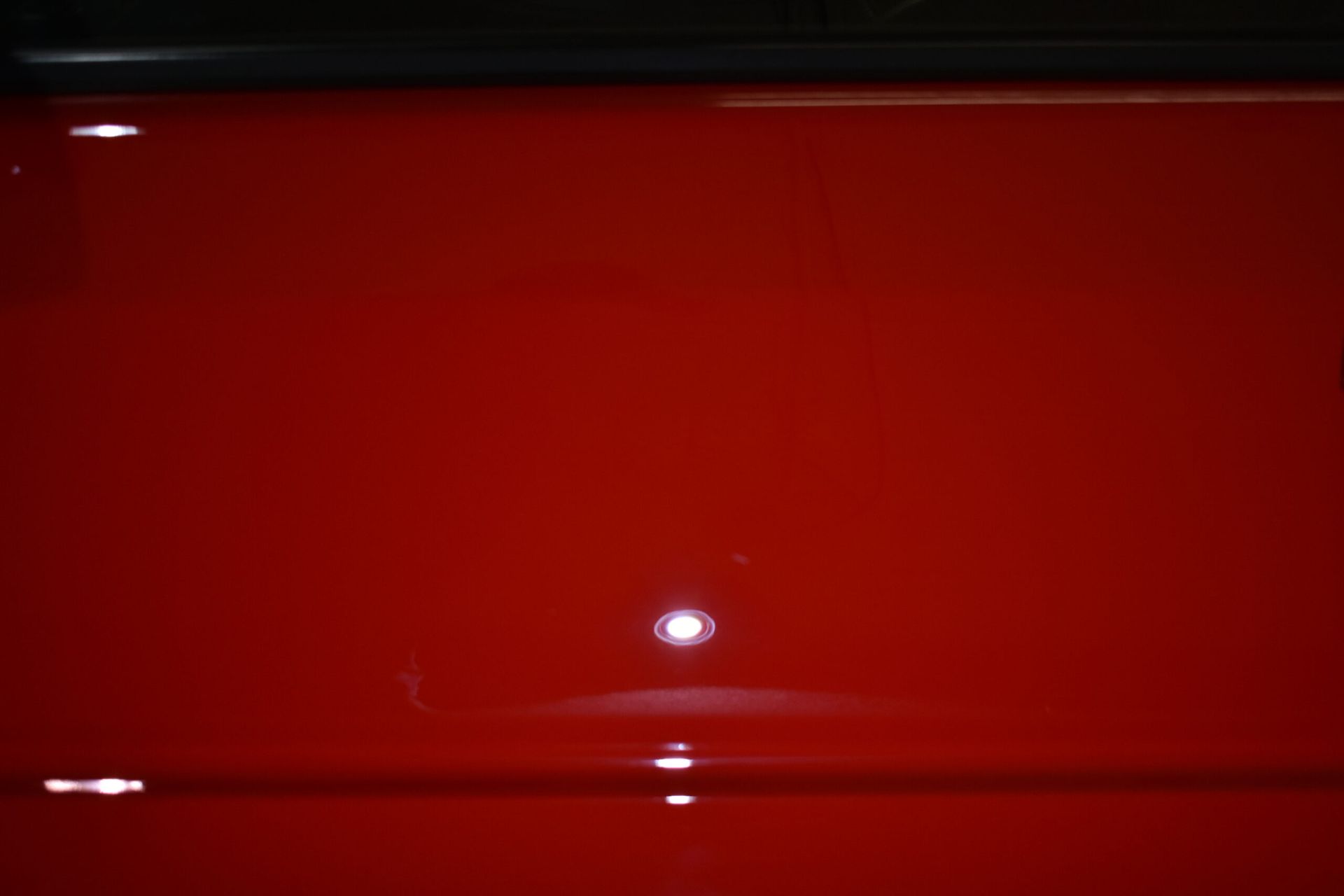 A close up of a red surface with a light shining on it.