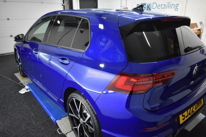 A blue car is sitting on a lift in a garage.