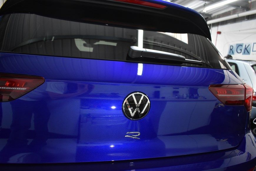 A blue volkswagen golf r is parked in a garage.