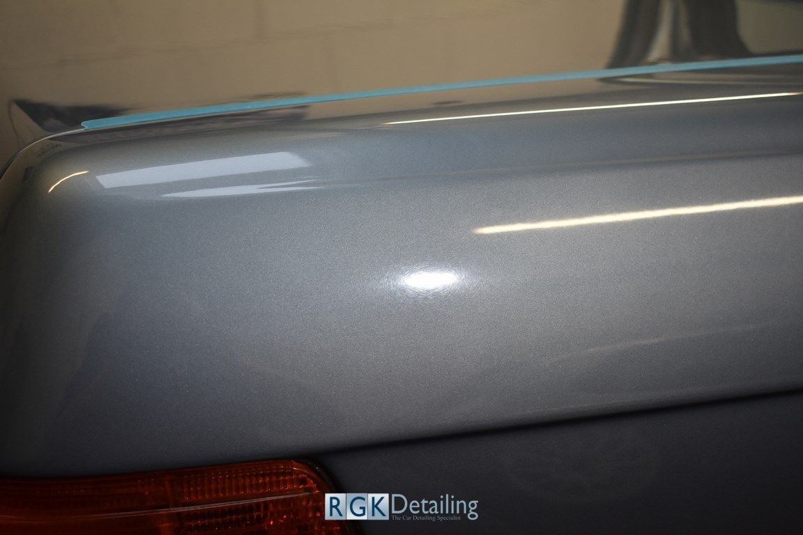 A close up of a car 's trunk with a blue tape covering it.