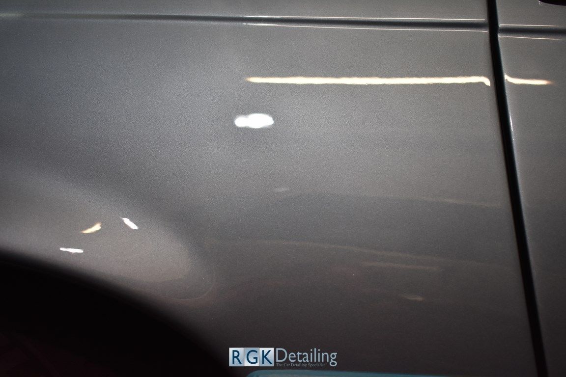 A close up of a gray car door with the words rgk detailing on it
