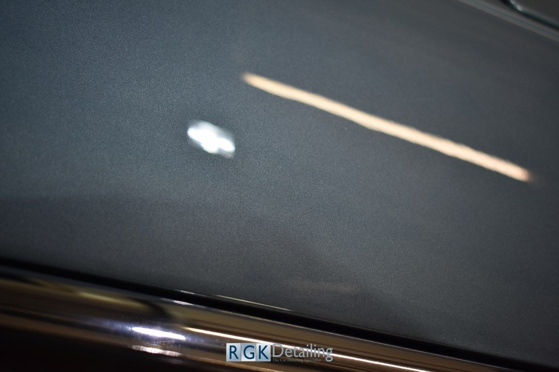 A close up of the hood of a car with the word rgk on it