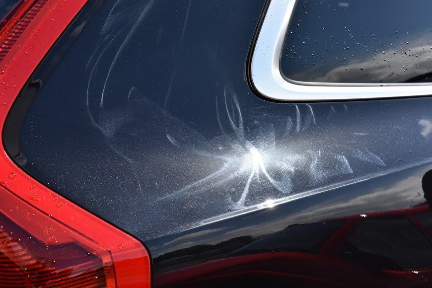 A close up of a black car with a red tail light