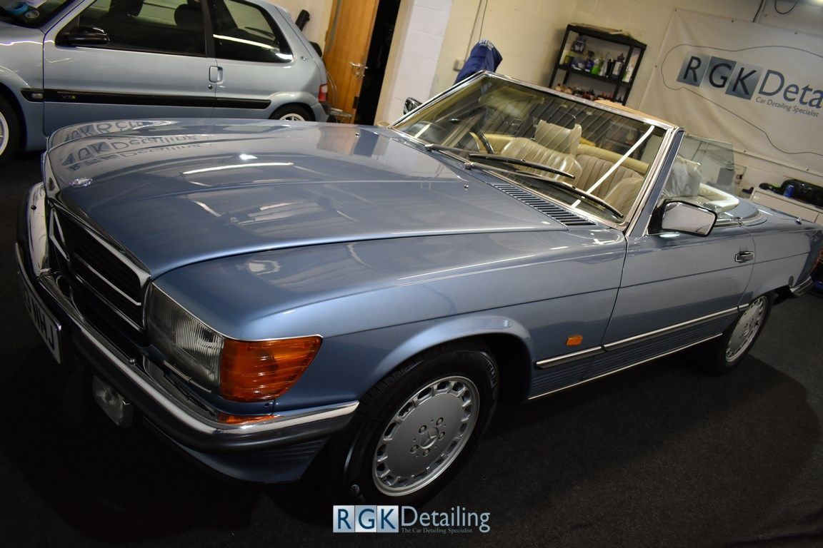 A blue mercedes benz sl500 is parked in a garage