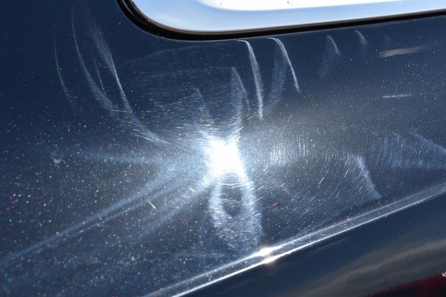 A close up of a car with a lot of scratches on it