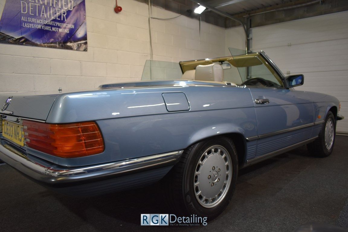 A blue convertible car is parked in a garage.