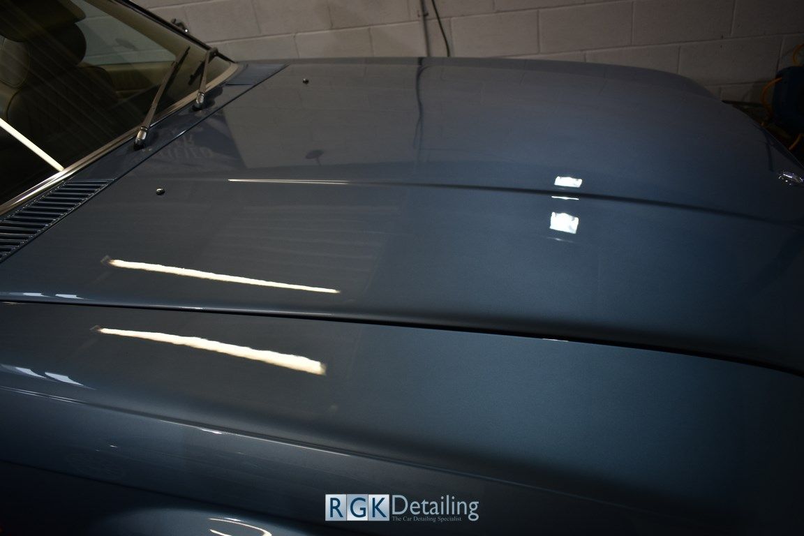 A close up of the hood of a car that says rgk detailing