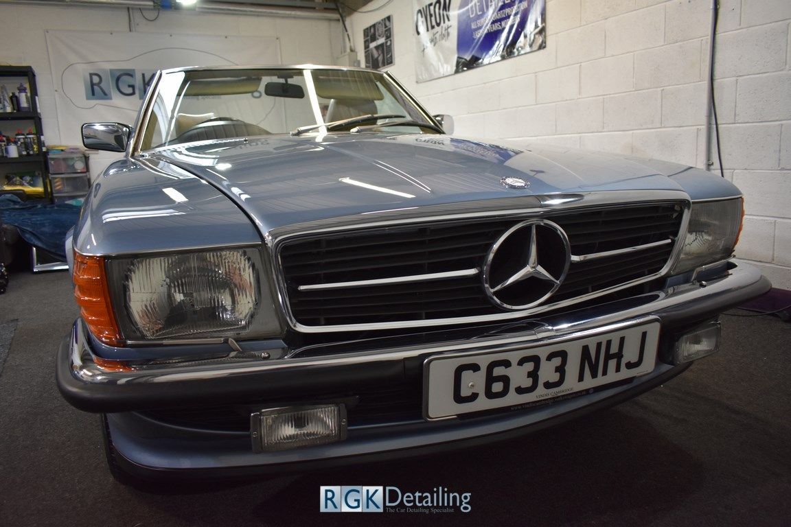 A blue mercedes benz is parked in a garage.