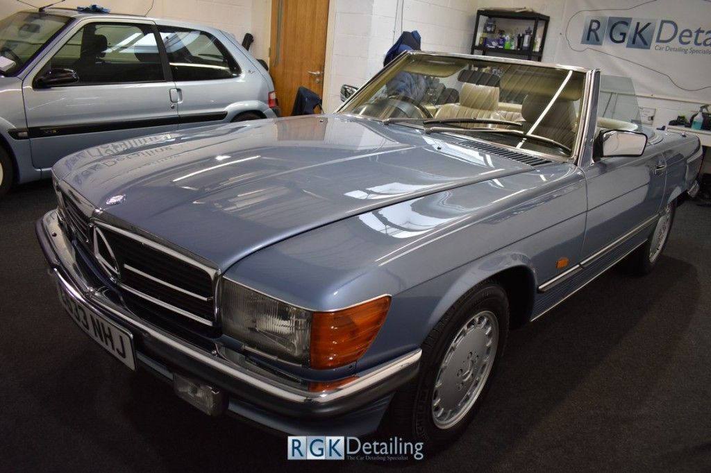 A blue mercedes benz is parked in a garage