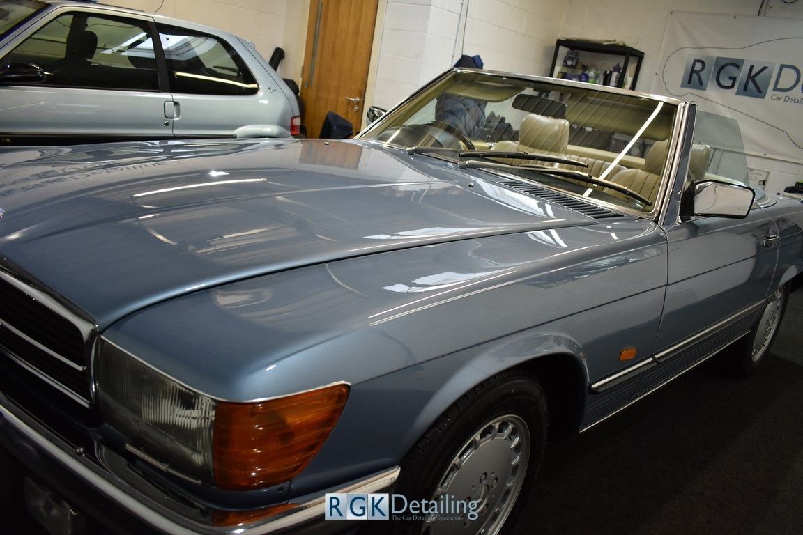 A blue convertible car is parked in a garage.