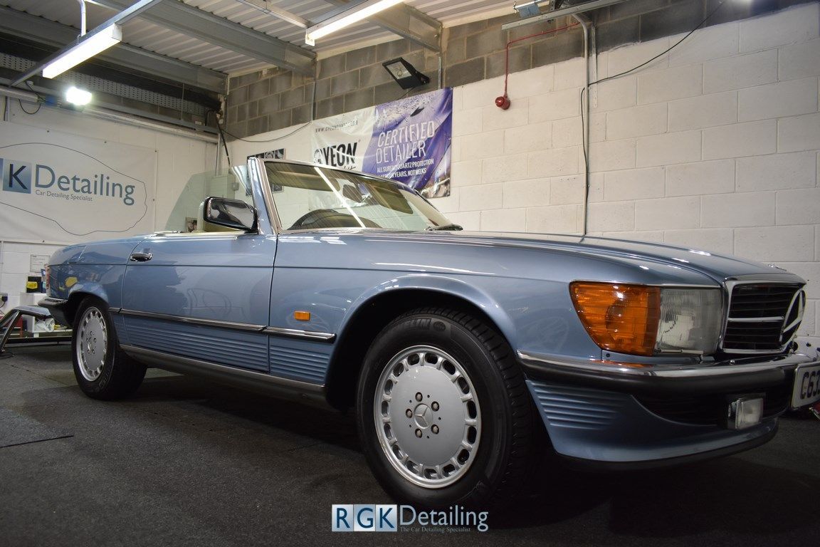 A blue mercedes benz sl500 is parked in a garage.