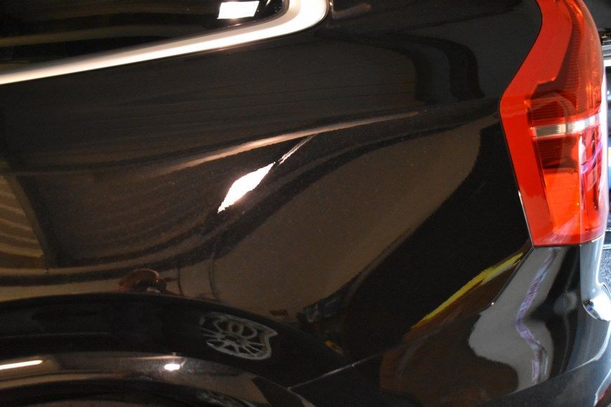 A black car with a red tail light that says kid 's car