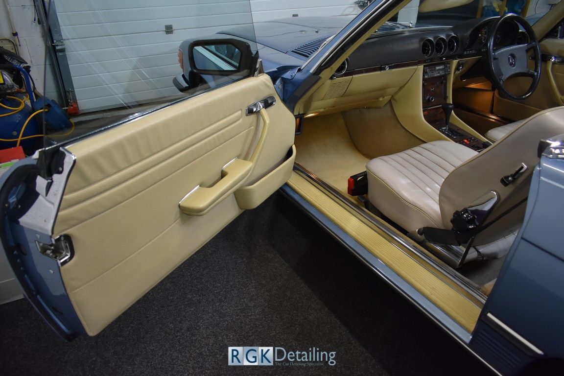 The inside of a car with the door open and the words rgk detailing on the bottom