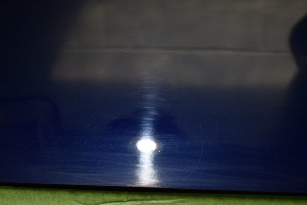 A close up of a blue surface with a light shining on it.