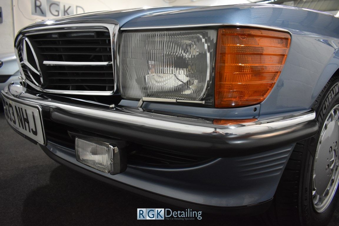 A close up of the front of a blue mercedes benz