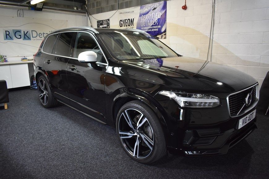 A black volvo xc90 is parked in a garage.
