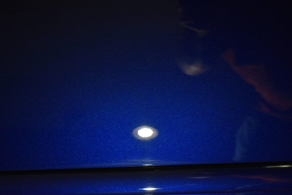 A close up of a blue surface with a light shining on it.