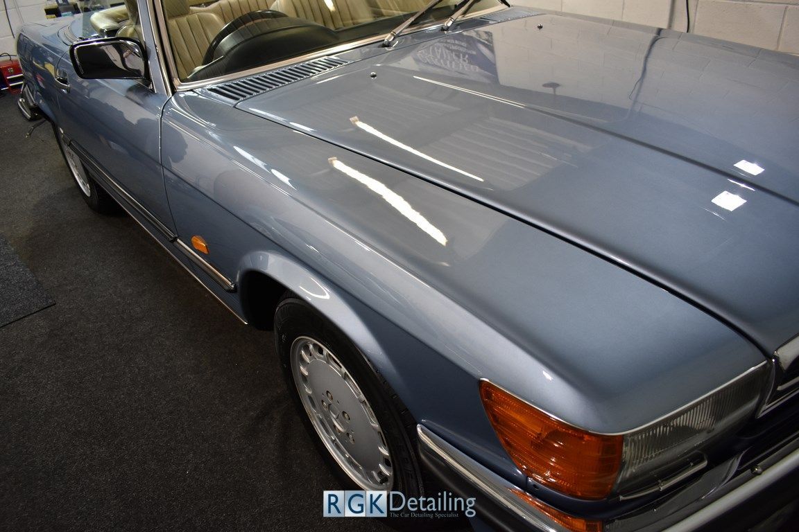 A close up of a blue car with the word rgk decaling on the bottom