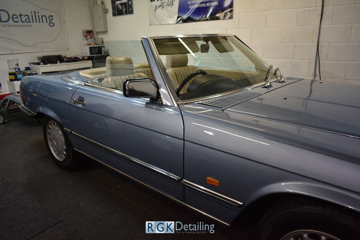 A blue convertible car is parked in a garage.