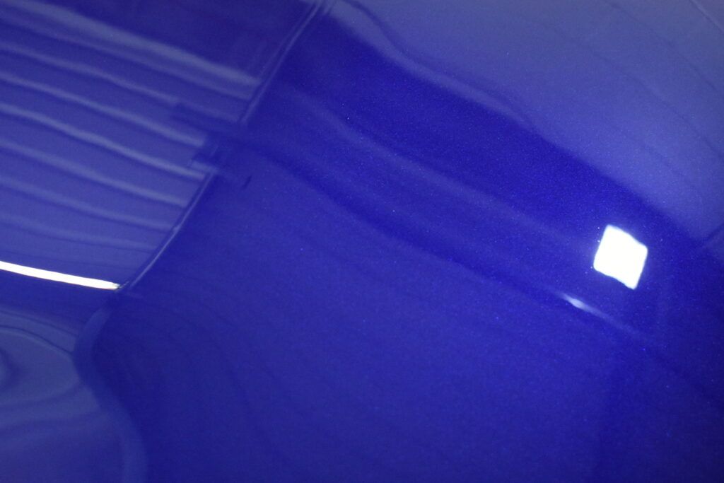 A close up of a blue object with a light shining on it.