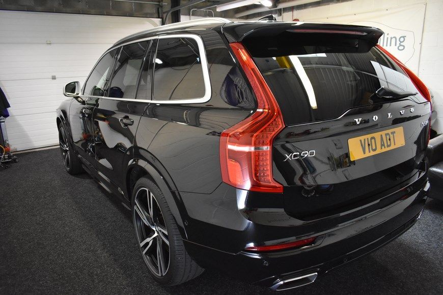 A black volvo xc90 is parked in a garage.