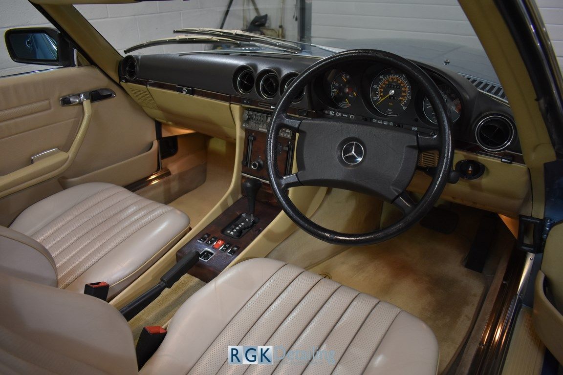 The interior of a mercedes with a steering wheel and seats
