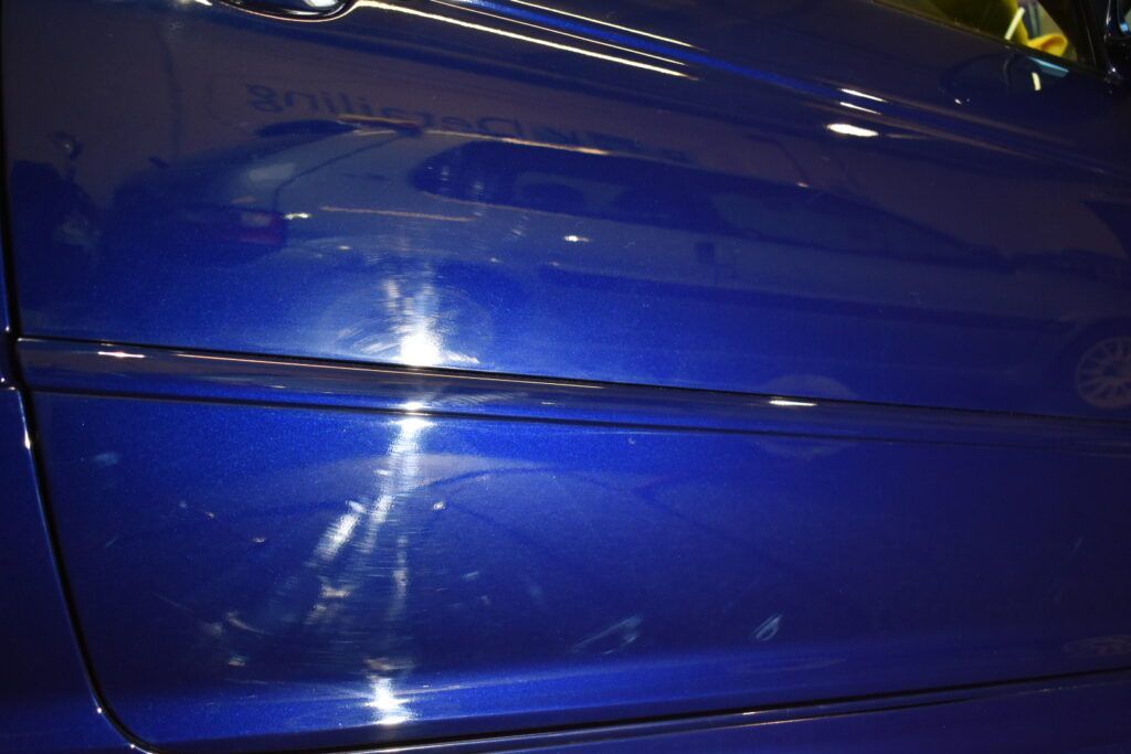 A close up of the side of a blue car
