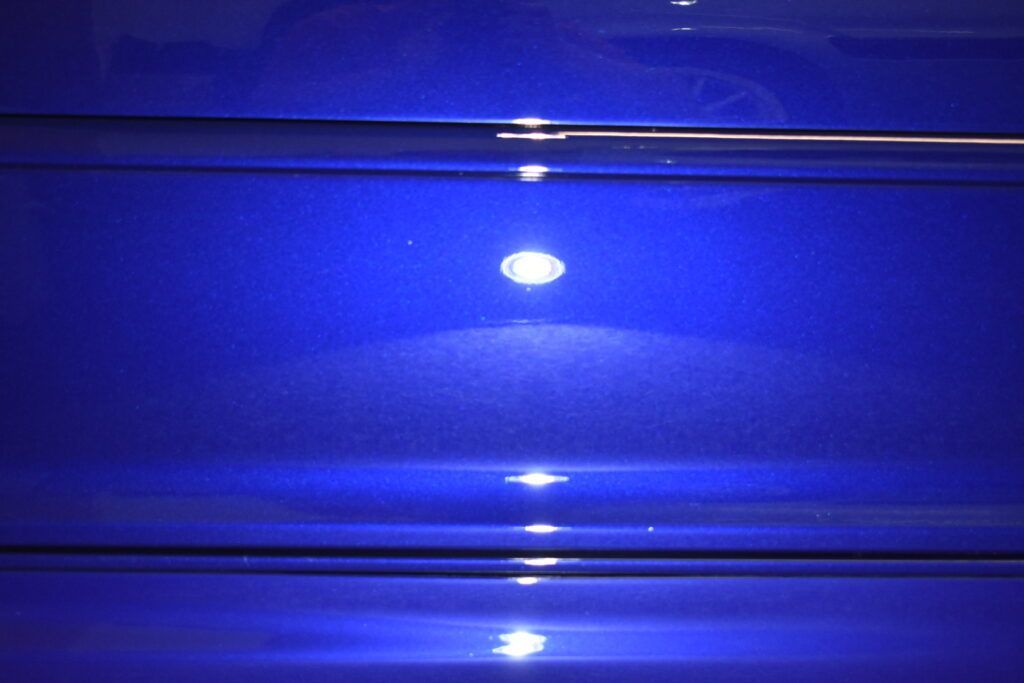 A close up of a blue object with a light shining on it.