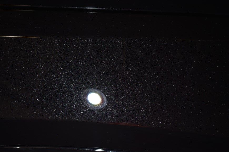 A close up of a black surface with a white spot on it.