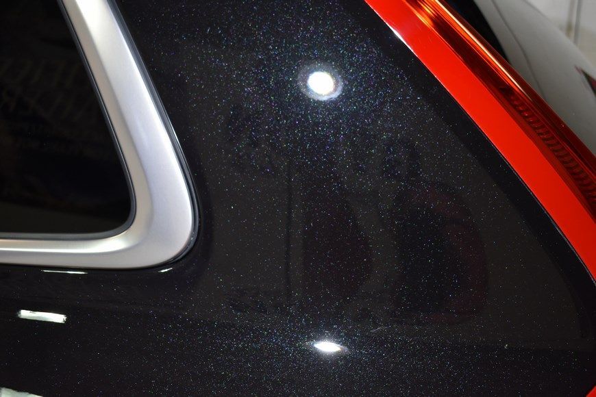 A close up of a black car with a red tail light