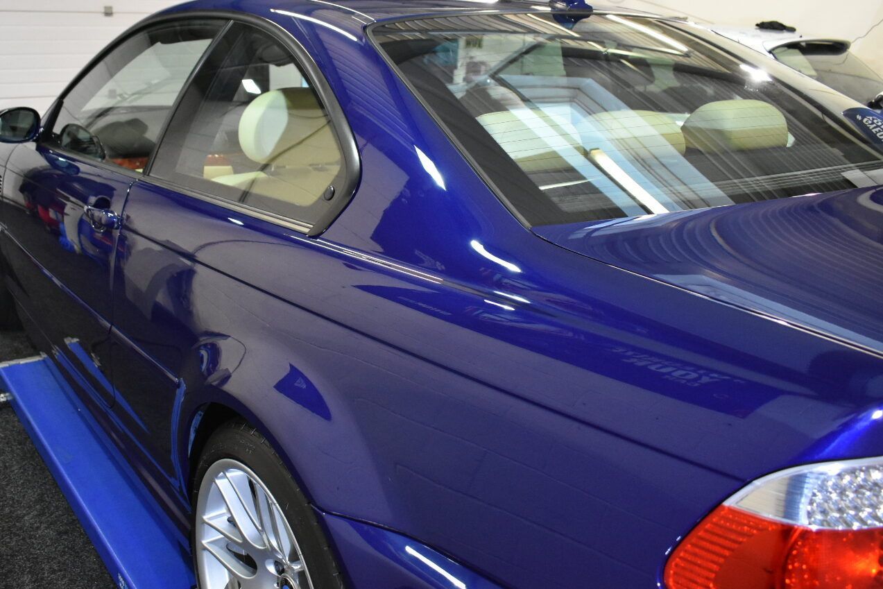 A blue car is sitting on a lift in a garage