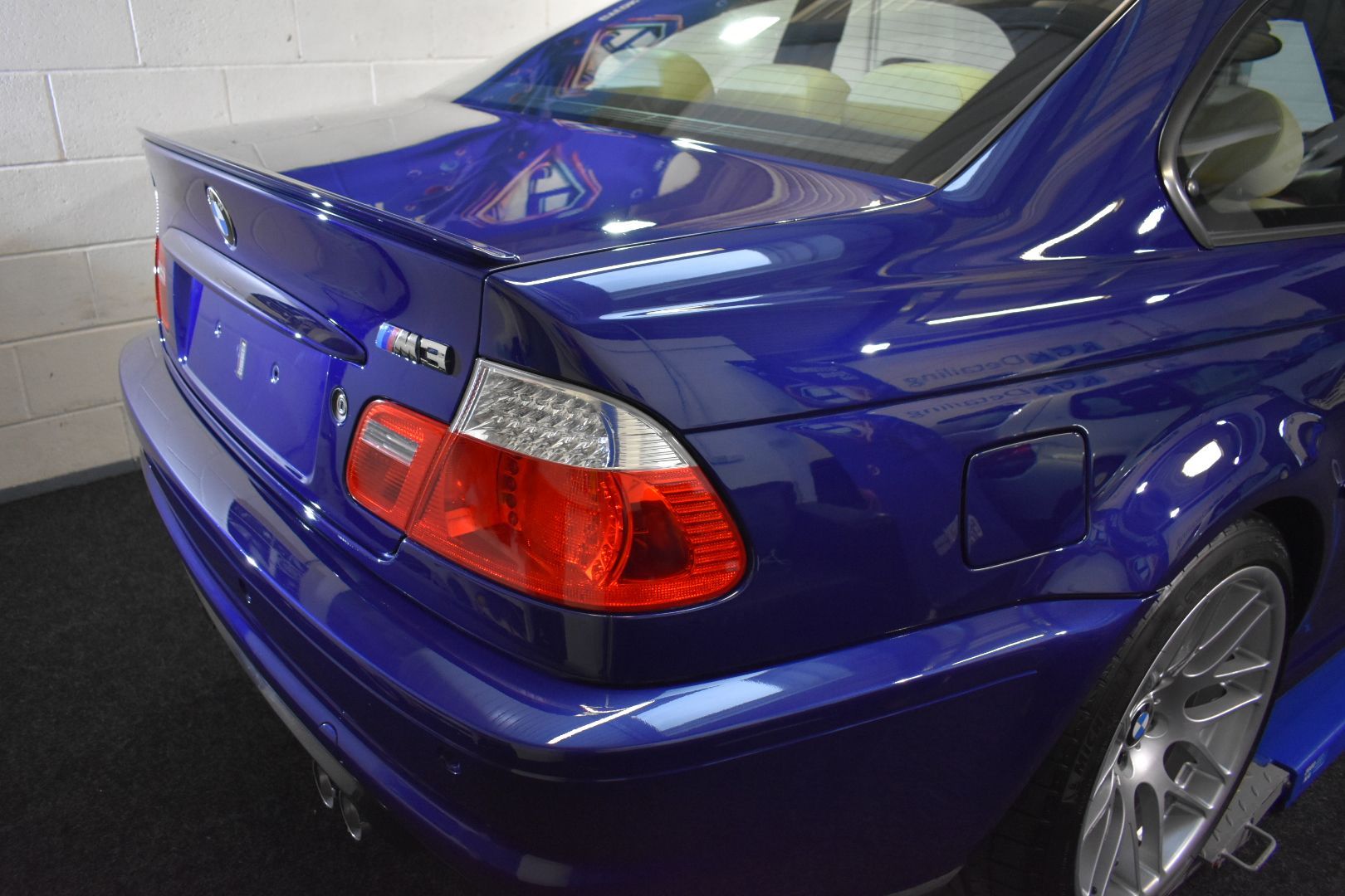 A blue bmw m3 is parked in a garage.