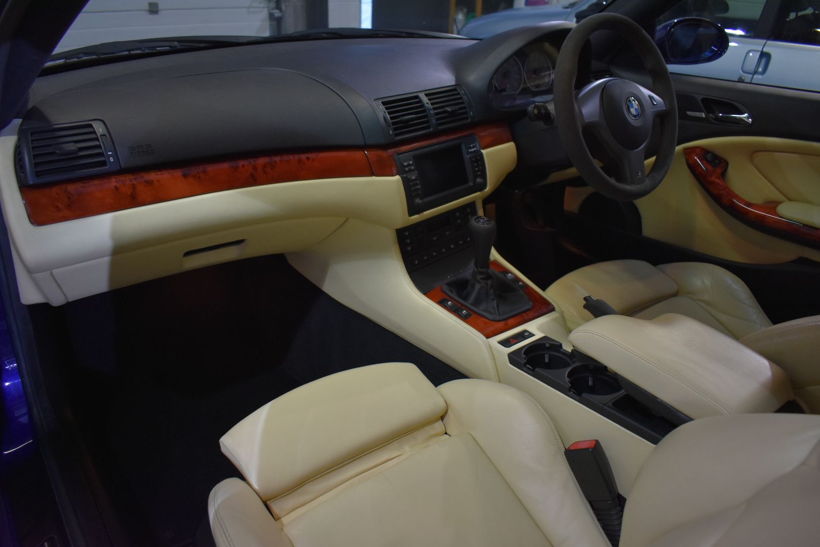 The interior of a car with tan leather seats and wood trim
