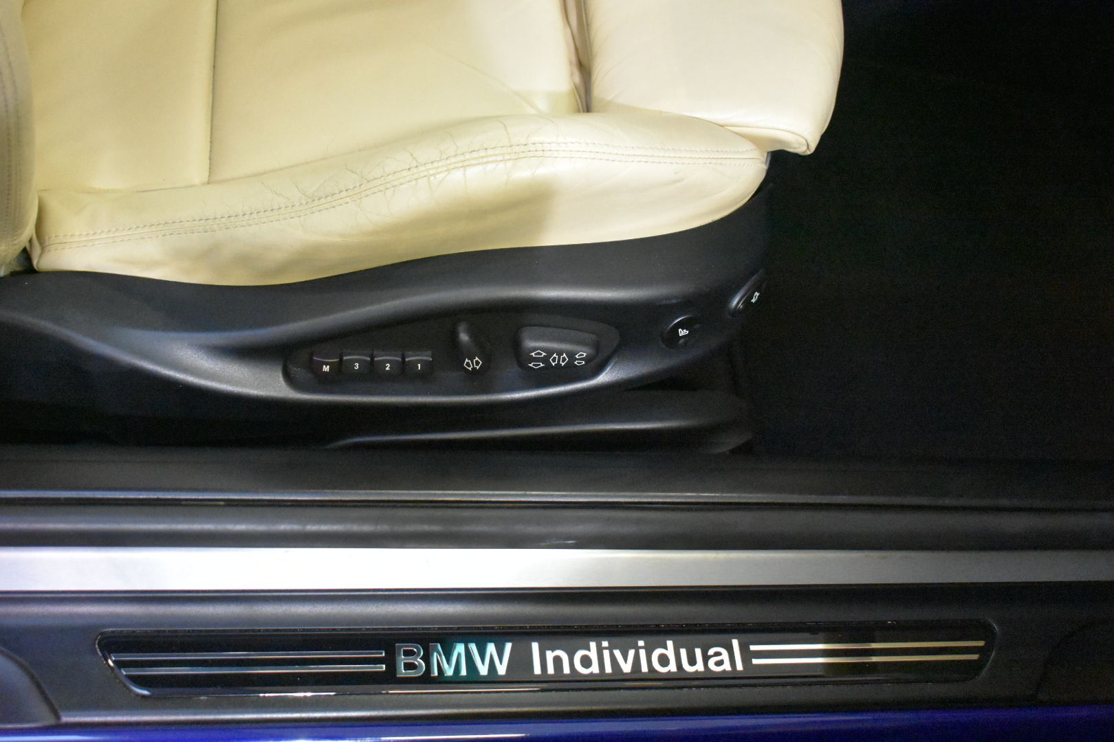 A bmw individual logo is on the door of a car
