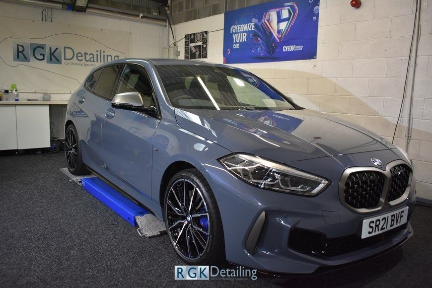 A bmw is sitting on a lift in a garage.