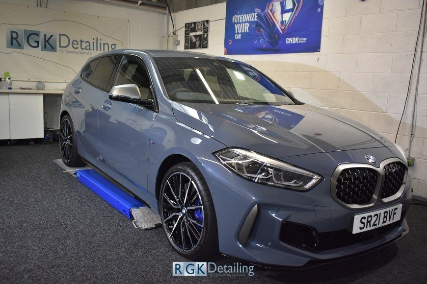 A bmw is sitting on a lift in a garage.