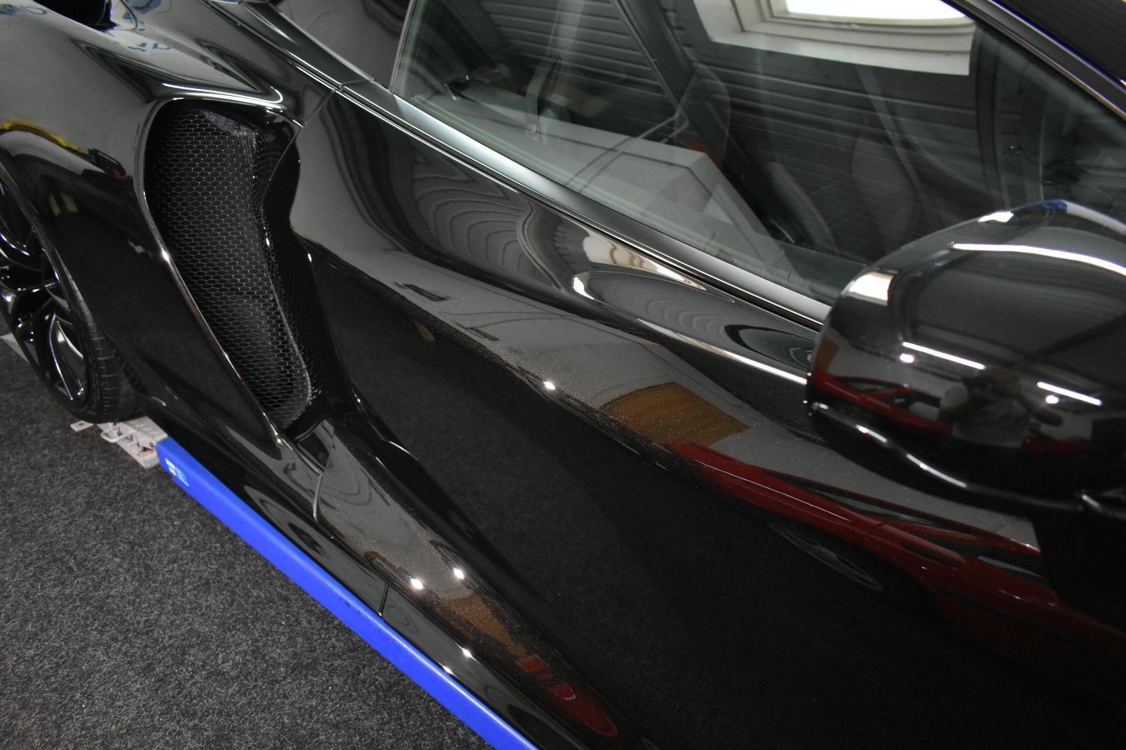 A black sports car with blue stripes on the side