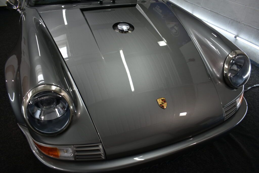 A silver porsche is parked in a garage