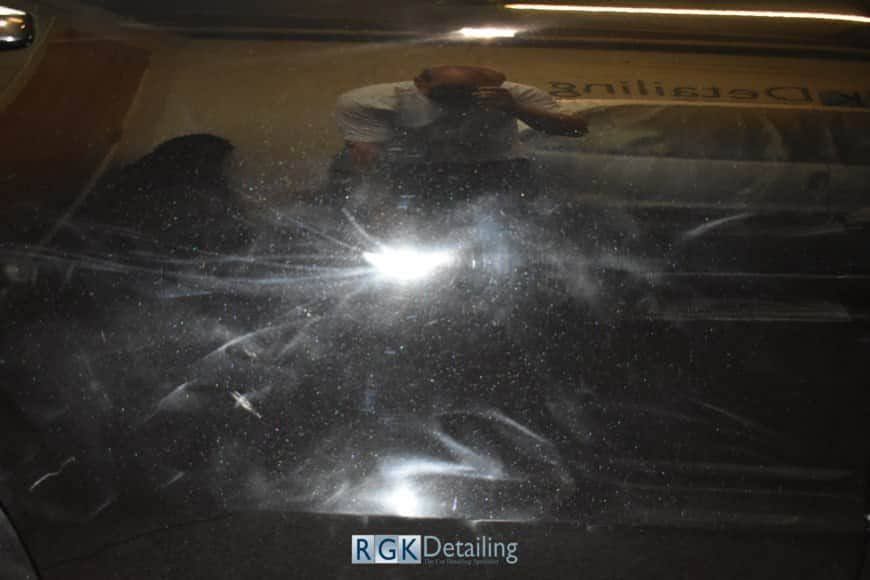 A man is standing in front of a rgk decaling machine.