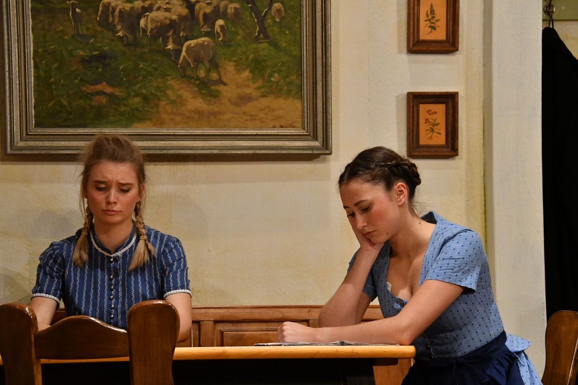 Zwei Schauspielerinnen der Theatergruppe Emmering sitzen traurig an einem Tisch im Stück 