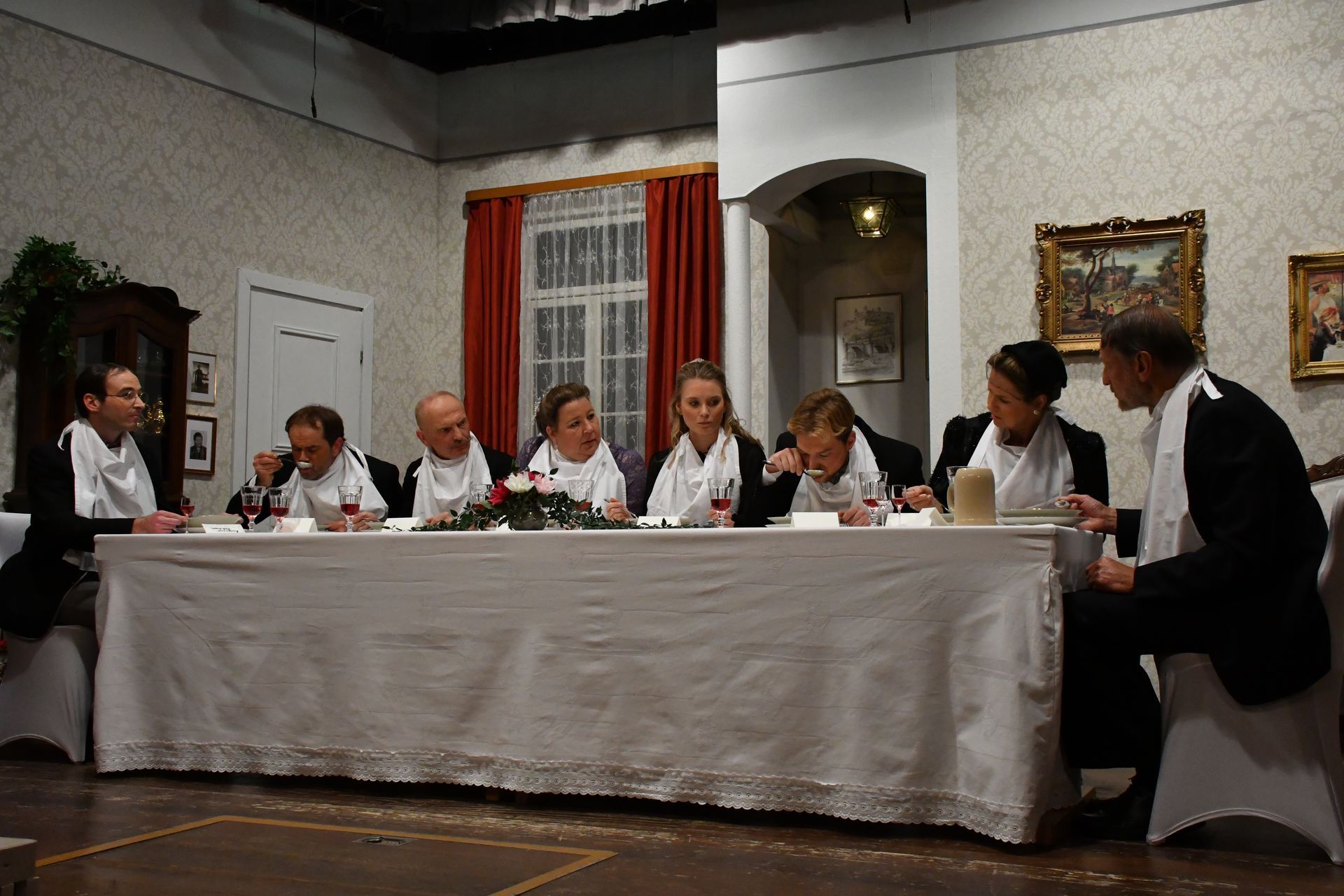 Acht Schauspieler der Theatergruppe Emmering auf der Bühne am Esstisch im Stück 