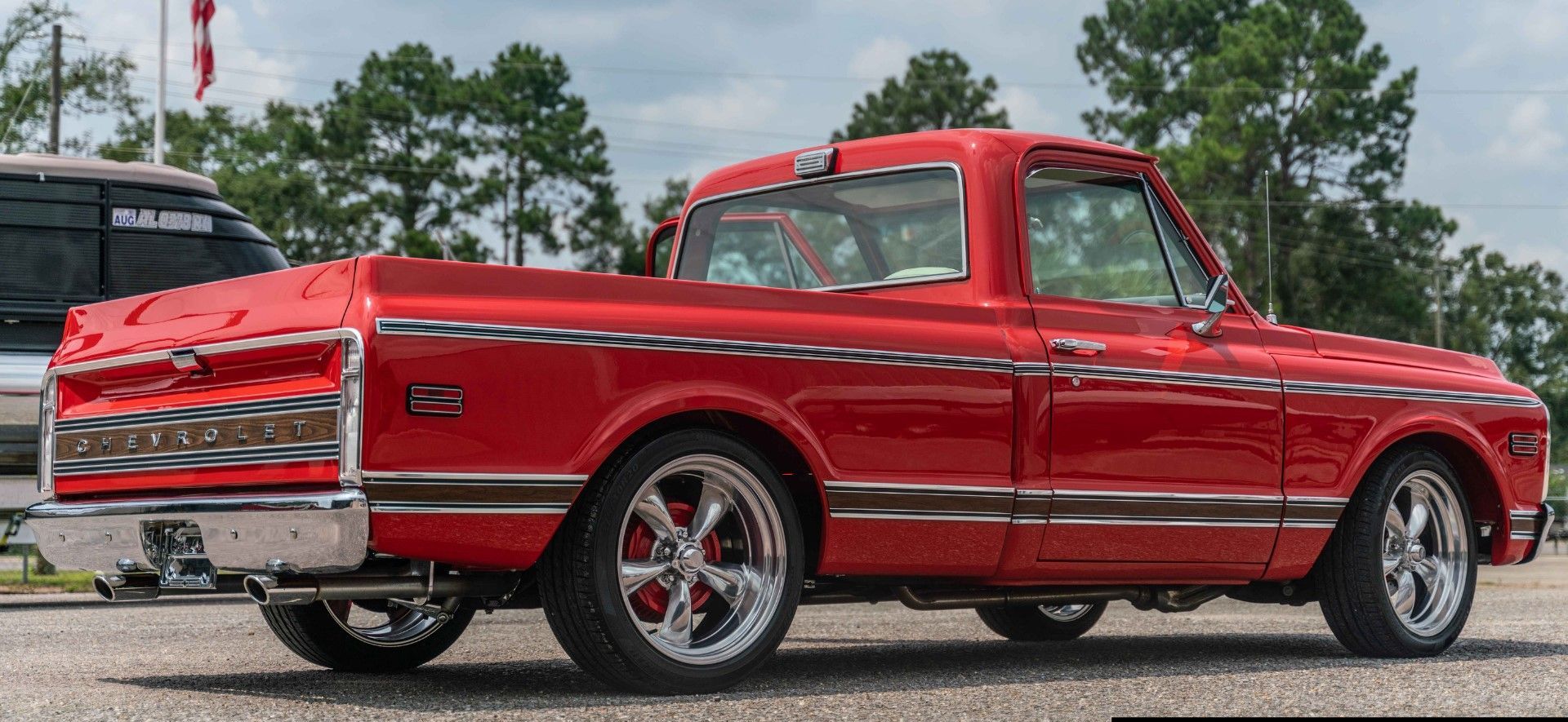 A motorcycle is parked in front of a boat in a garage.